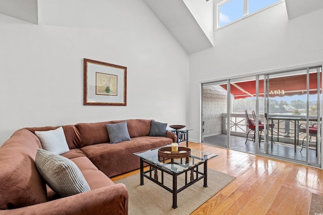 living room with high vaulted ceiling and light hardwood / wood-style floors