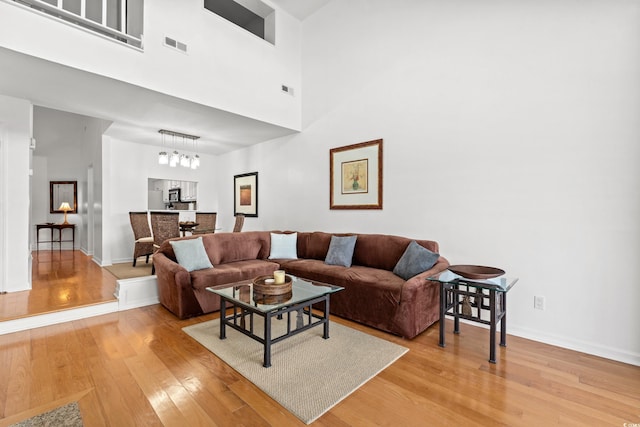 living room featuring a towering ceiling and wood-type flooring