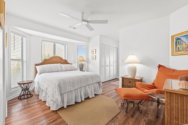 bedroom with dark hardwood / wood-style floors, ceiling fan, and a closet