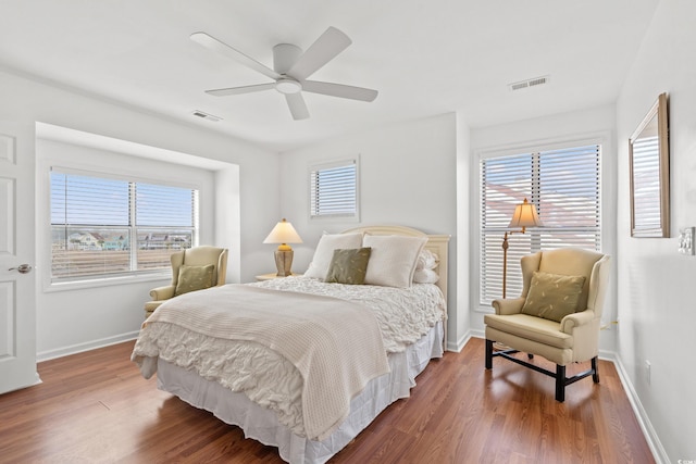 bedroom with multiple windows, hardwood / wood-style floors, and ceiling fan