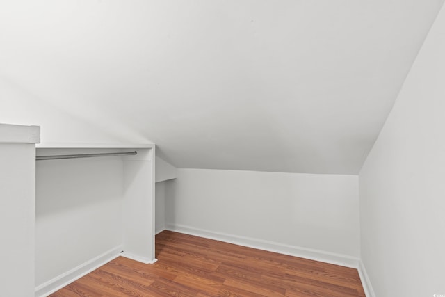 walk in closet with dark wood-type flooring and lofted ceiling