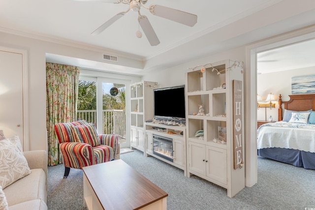 living area with light carpet, a ceiling fan, visible vents, and crown molding