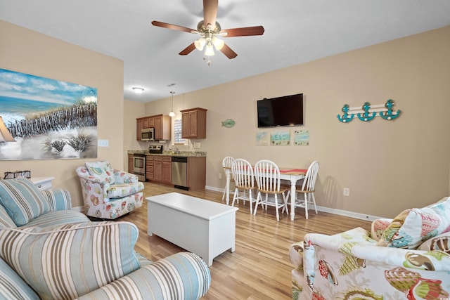 living room with light hardwood / wood-style floors and ceiling fan