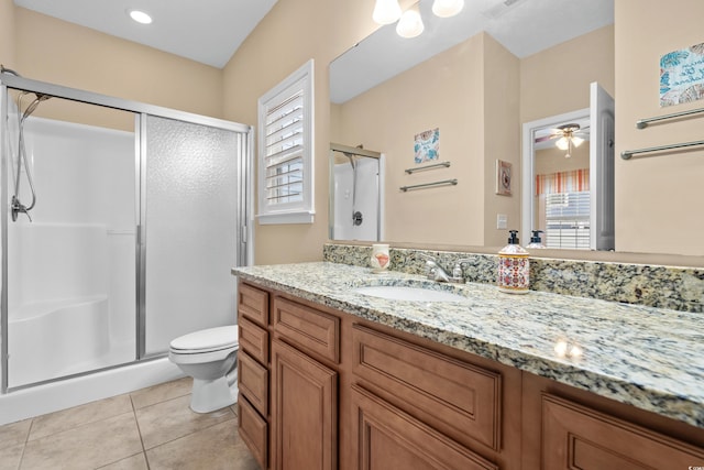 bathroom featuring a shower with door, vanity, tile patterned floors, and toilet