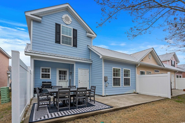 back of property with central AC unit and a patio