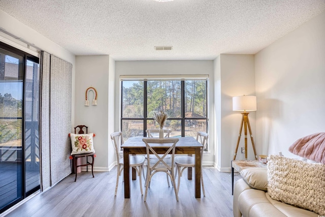 dining room with baseboards, visible vents, and wood finished floors