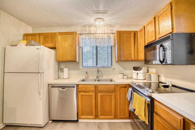 kitchen with appliances with stainless steel finishes, light countertops, visible vents, and a sink