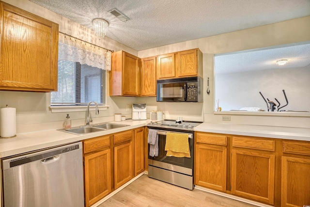 kitchen with a textured ceiling, visible vents, stainless steel appliances, and a sink