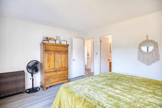 bedroom featuring light wood-style floors and baseboards