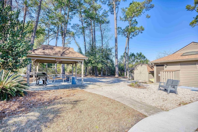 view of yard with an outdoor structure, a gazebo, and a storage unit
