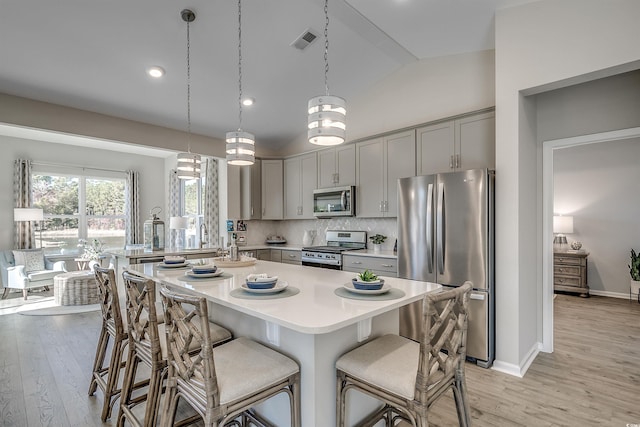 kitchen with light countertops, gray cabinetry, appliances with stainless steel finishes, and light wood-style floors