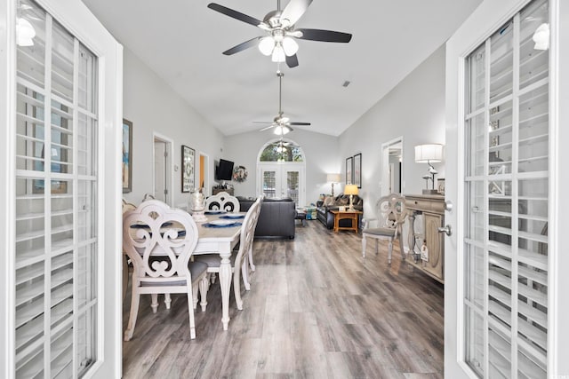 dining room featuring lofted ceiling, hardwood / wood-style flooring, french doors, and ceiling fan