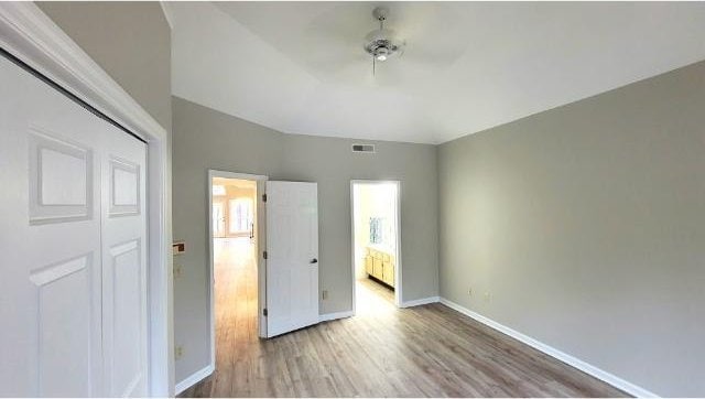 unfurnished bedroom with hardwood / wood-style flooring, a closet, and ceiling fan