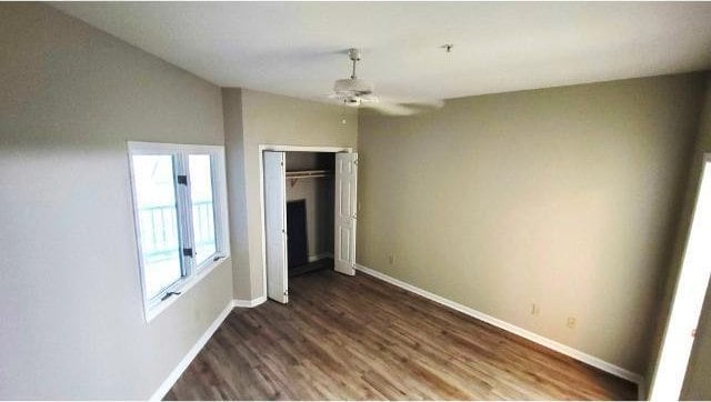 unfurnished bedroom with ceiling fan, lofted ceiling, dark hardwood / wood-style flooring, and a closet