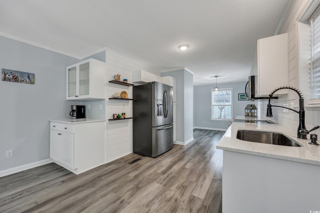 kitchen with tasteful backsplash, wood finished floors, stainless steel appliances, open shelves, and a sink