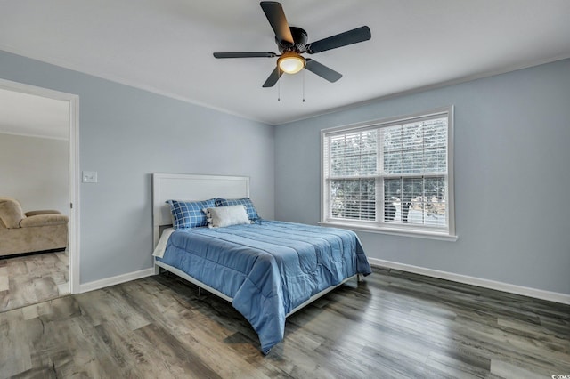 bedroom with ceiling fan, baseboards, wood finished floors, and ornamental molding