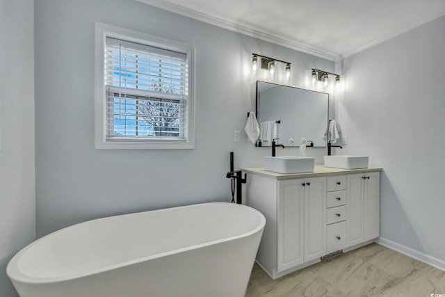 full bathroom featuring a freestanding bath, marble finish floor, double vanity, and a sink