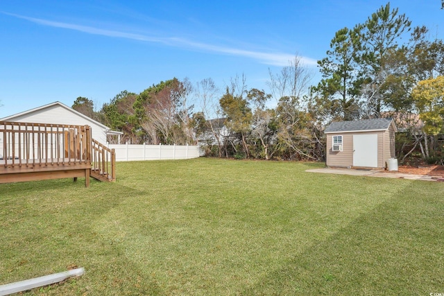 view of yard with a shed, an outdoor structure, a fenced backyard, and a wooden deck