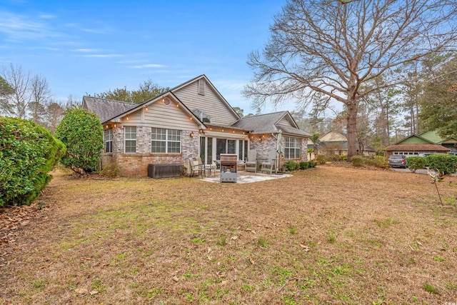 rear view of property with a lawn and a patio area