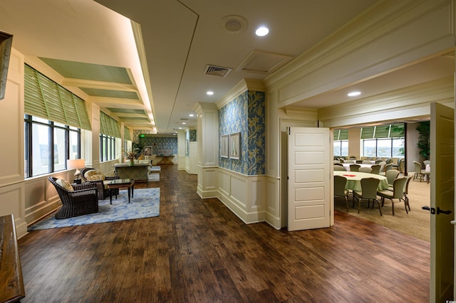 corridor with crown molding, plenty of natural light, and dark hardwood / wood-style floors