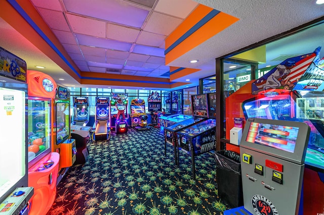 game room featuring a drop ceiling, a tray ceiling, and carpet flooring