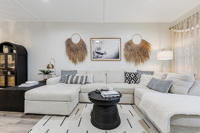 living room with light hardwood / wood-style flooring and ornamental molding