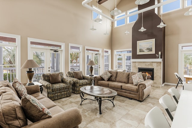 tiled living room featuring french doors, plenty of natural light, and a tile fireplace