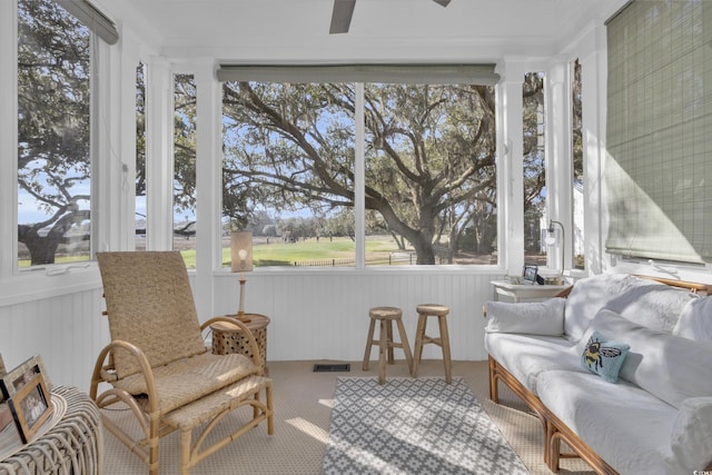 sunroom with a healthy amount of sunlight, visible vents, and ceiling fan