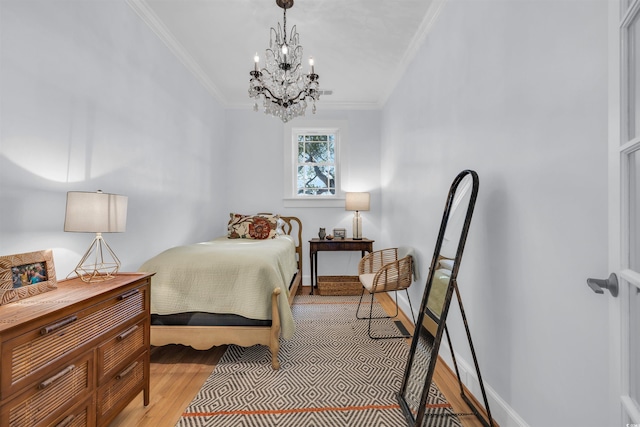 bedroom featuring light wood finished floors, baseboards, a chandelier, and crown molding