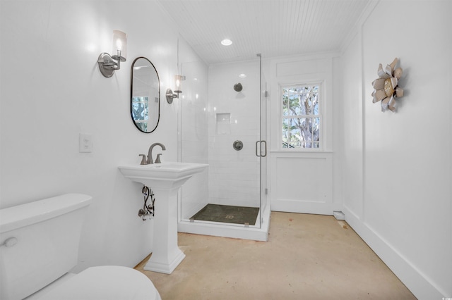 full bath featuring concrete floors, a shower stall, toilet, and baseboards