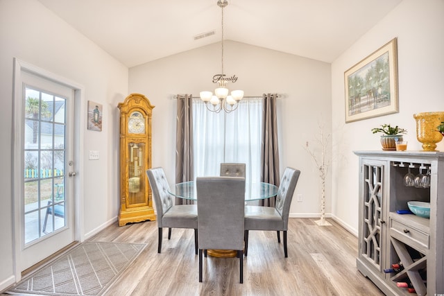 dining area with lofted ceiling, an inviting chandelier, and light hardwood / wood-style floors