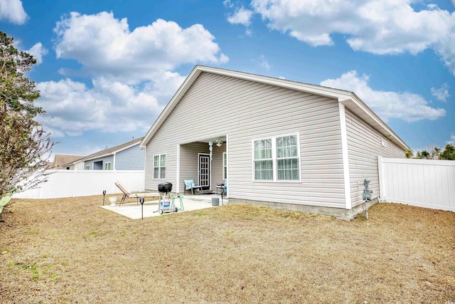 back of house with a lawn and a patio area