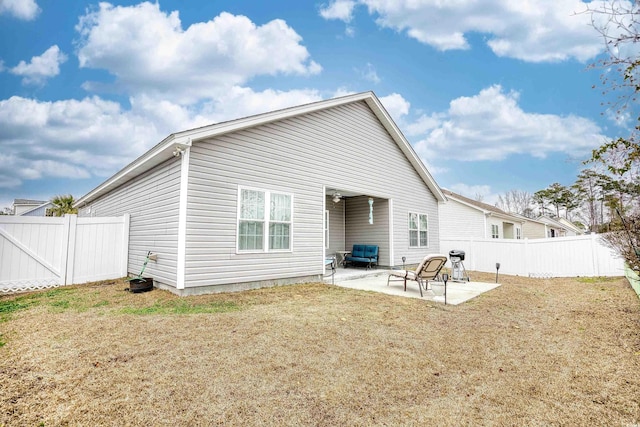 rear view of property featuring a patio area and a lawn