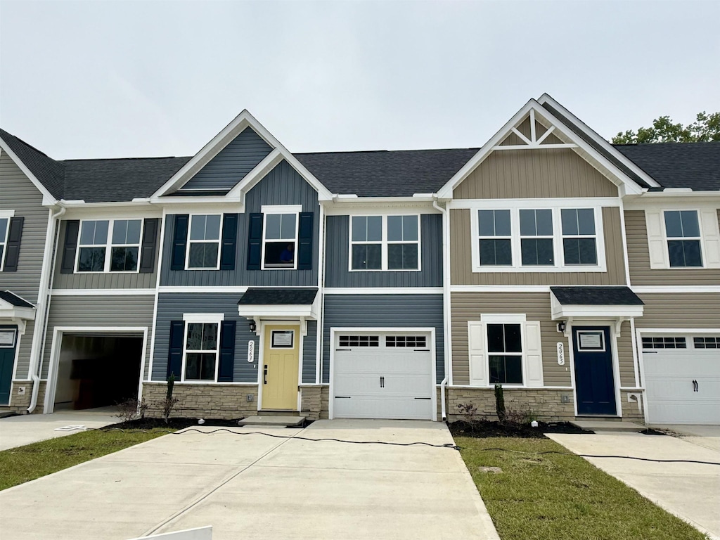 2063 NW Parow Ln NW Unit E, Calabash, NC 28467 - view of front of property featuring stone siding, concrete driveway, board and batten siding, and a garage