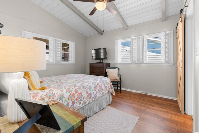 bedroom with multiple windows, hardwood / wood-style flooring, vaulted ceiling with beams, and a barn door