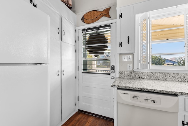 kitchen with dark wood-type flooring, white appliances, white cabinets, and light stone counters