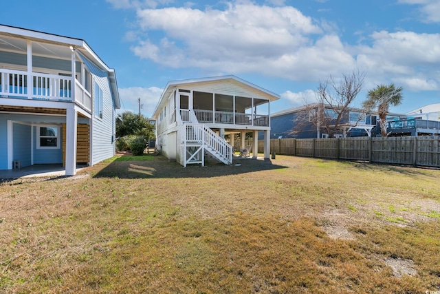 back of property with a lawn and a sunroom