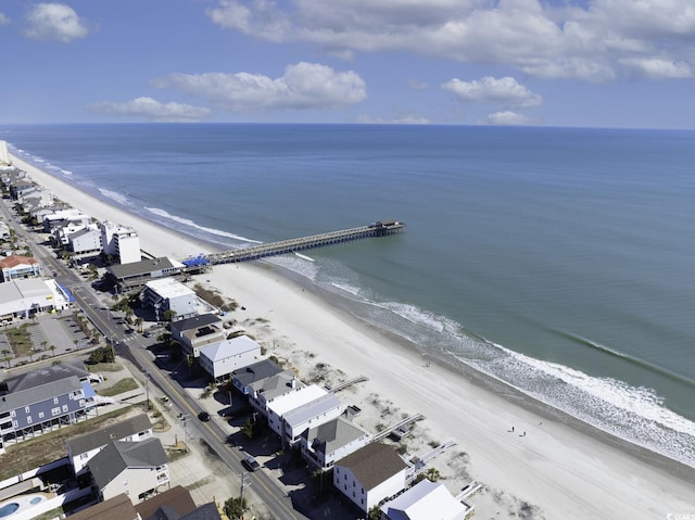 birds eye view of property with a water view and a beach view