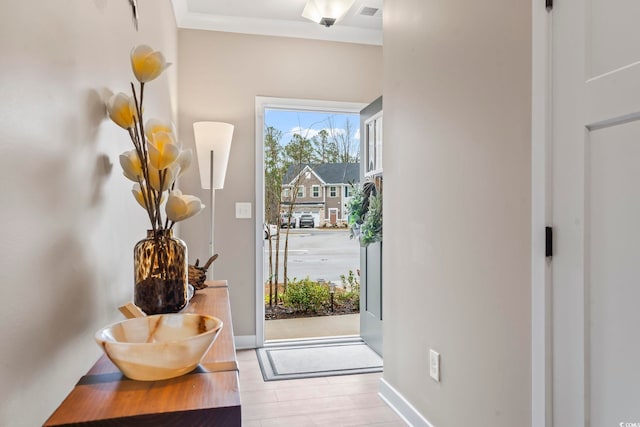 entryway featuring crown molding and light hardwood / wood-style flooring