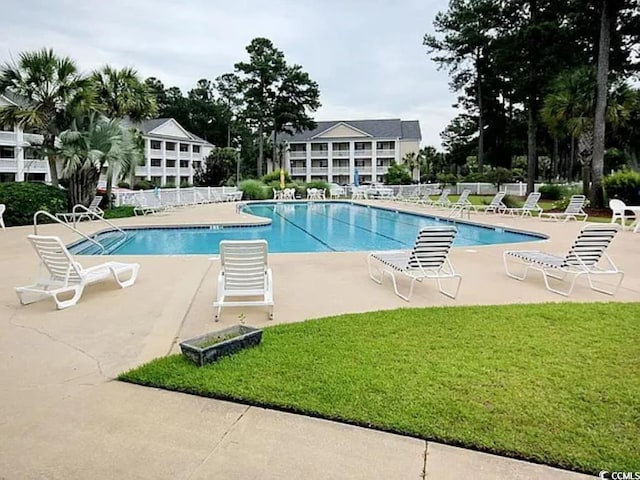 view of swimming pool featuring a yard and a patio area