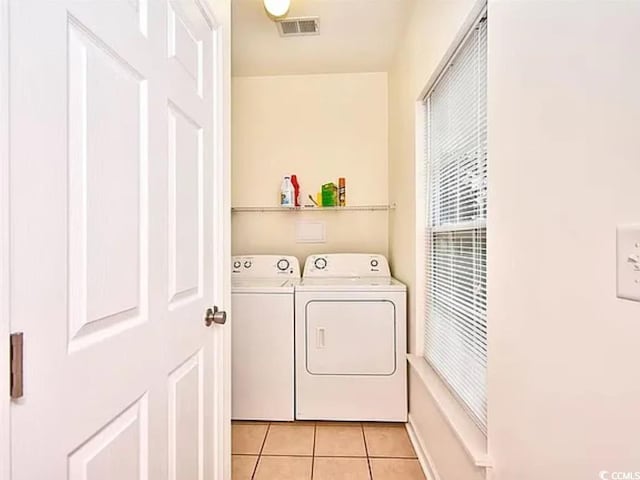 laundry room featuring light tile patterned flooring and separate washer and dryer