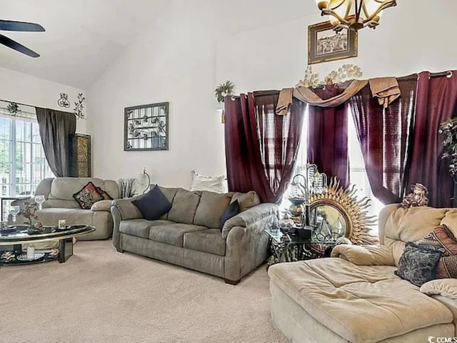 living room with light colored carpet, high vaulted ceiling, and ceiling fan with notable chandelier