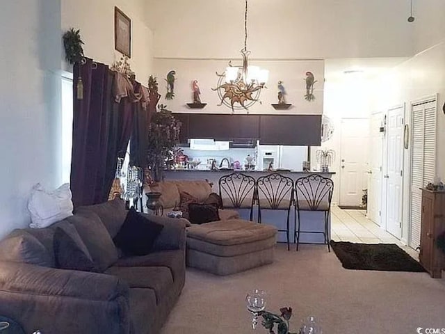 living room with a towering ceiling, light colored carpet, and a notable chandelier