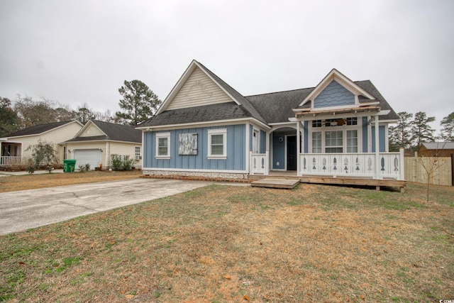 view of front of house featuring covered porch, a front lawn, and a garage