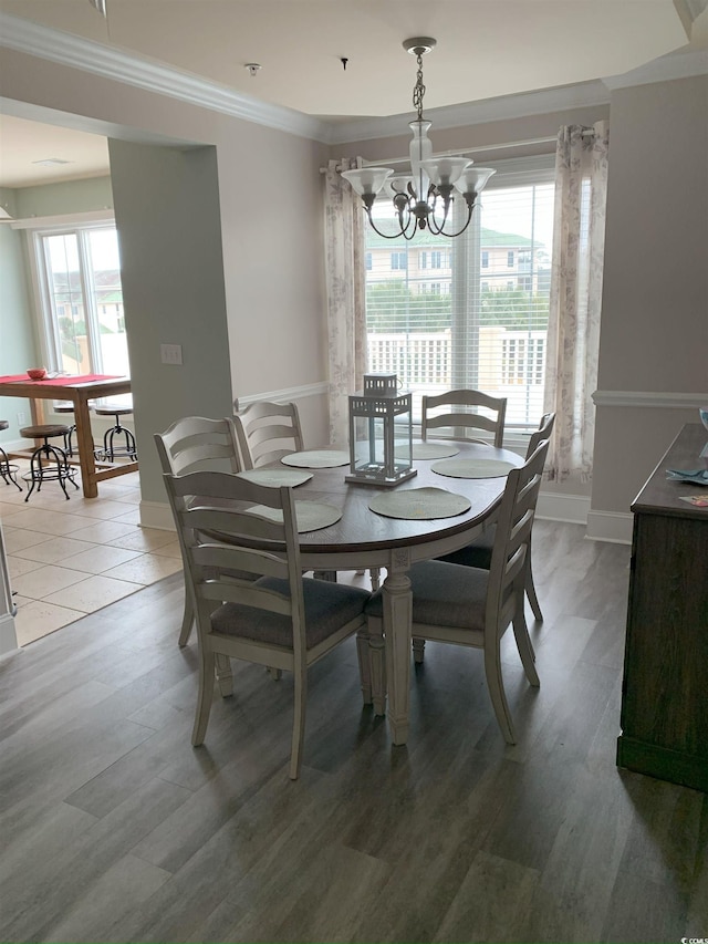 dining area with a healthy amount of sunlight, hardwood / wood-style flooring, and crown molding