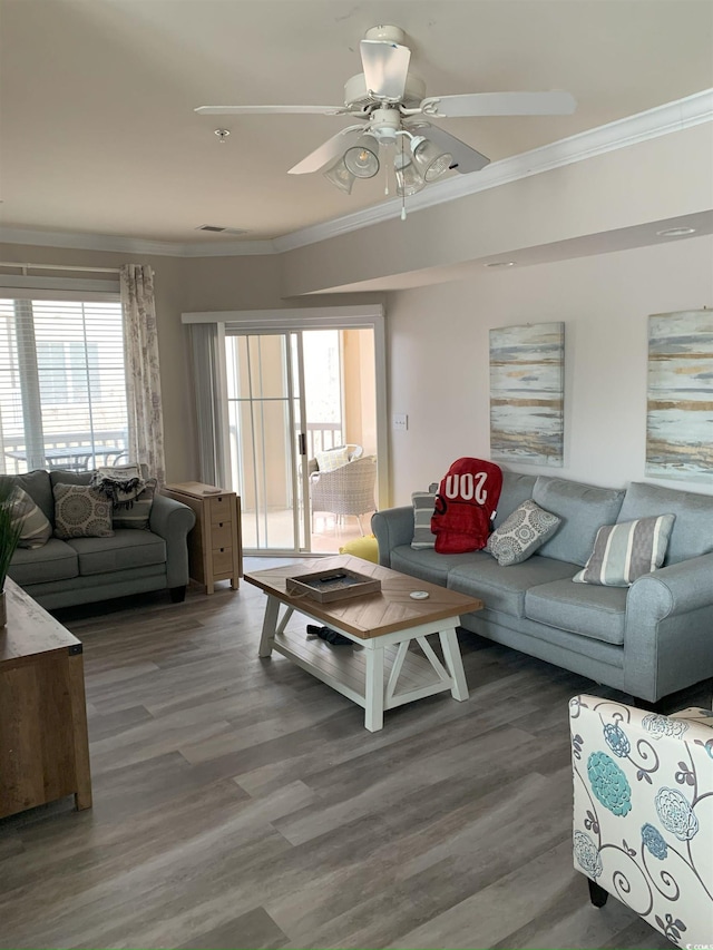 living room with plenty of natural light, dark wood-type flooring, and ornamental molding