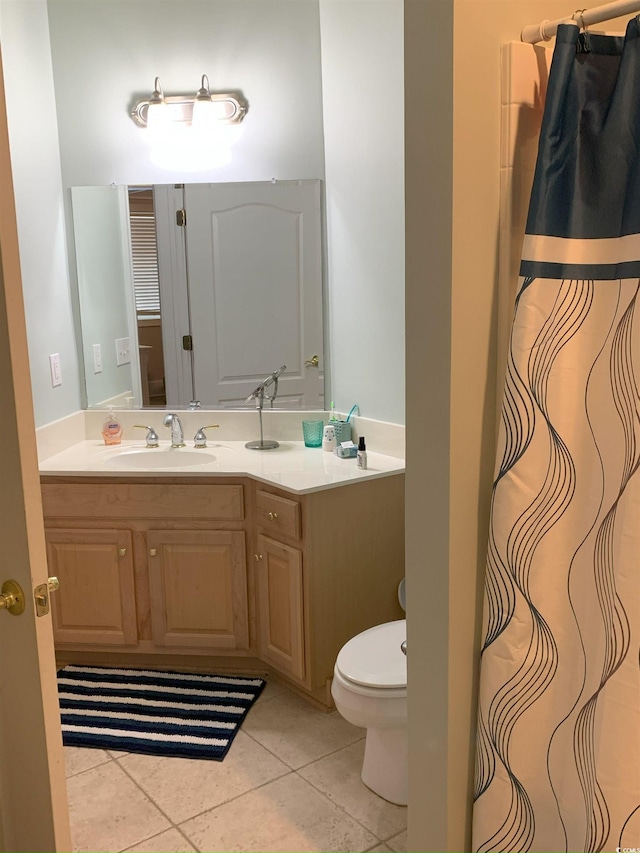 bathroom with toilet, tile patterned flooring, and vanity