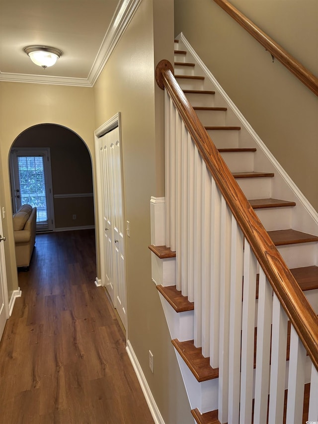 stairs featuring crown molding and wood-type flooring