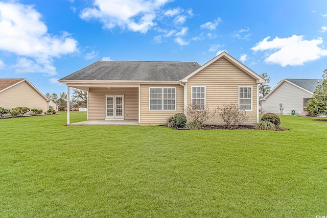 back of house featuring a patio, french doors, a lawn, and roof with shingles