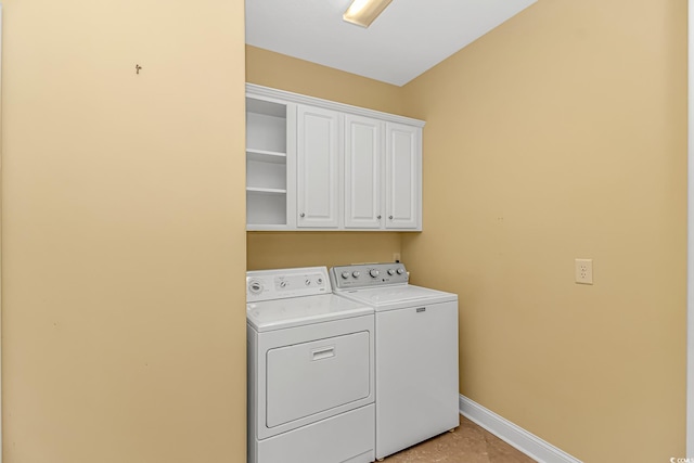 laundry room with washing machine and dryer, cabinet space, and baseboards